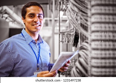 Portrait of technician analyzing server in server room