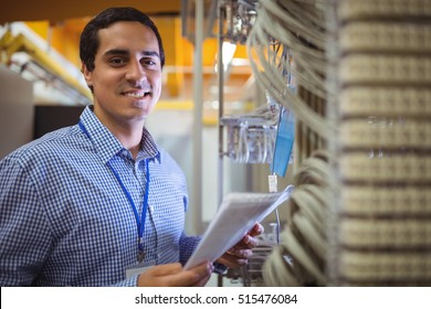 Portrait of technician analyzing server in server room