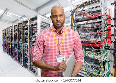Portrait Of IT Technician In Data Centre Standing By Servers