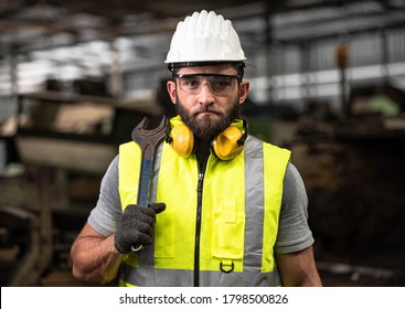 Portrait of technician man or industrial worker with hardhat or helmet, eye protection glasses, Tool and vest working electronic machinery on laptop and mechanical  in Factory of manufacturing place
