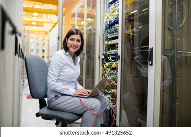 Portrait of technician working on laptop in server room - Powered by Shutterstock