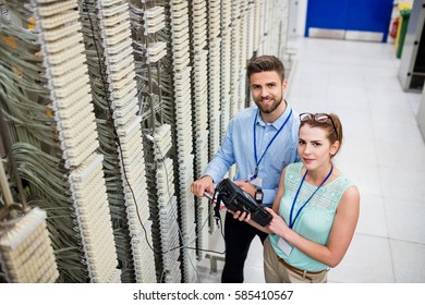 Portrait of technicians using digital cable analyzer in server room - Powered by Shutterstock