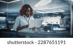 Portrait of a Technological Software Engineering Department Manager Standing and Using a Laptop Computer. African Female Looking in the Distance and Thinking while Working in the Office