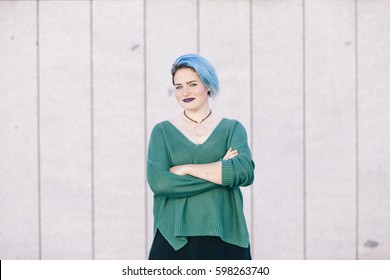 Portrait Of A Teen Androgynous Woman With Blue Dyed Hair Isolated On The Street Wearing A Blue Sweater.