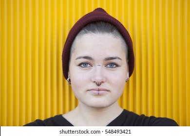 Portrait Of A Teen Androgynous Woman On A Yellow Wall