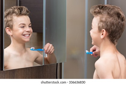 Portrait of a teen boy in the bathroom brushing his teeth - Powered by Shutterstock