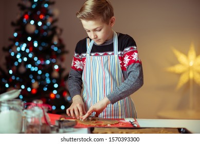 Portrait of teen boy making ginger cookies for Christmas eve at home with christmas tree on backgound - Powered by Shutterstock