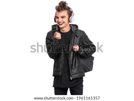 Portrait of teen boy student in headphones with spooking make-up holds bag, isolated on white background. Teenager with backpack in style of punk goth dressed in black. Problems of transitional age