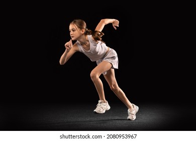 Portrait Of Teen Girl, Athlete Running, Training Isolated Over Black Background. Concept Of Action, Sport, Healthy Life, Competition, Motion, Physical Activity. Copy Space For Ad