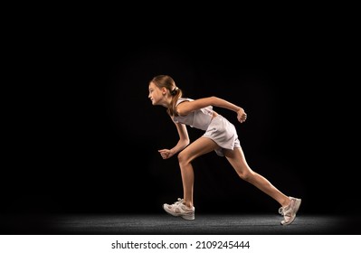 Portrait Of Teen Girl, Athlete Running, Training Isolated Over Black Background. Motivated Sportsman. Concept Of Action, Sport, Healthy Life, Competition, Motion, Physical Activity. Copy Space For Ad