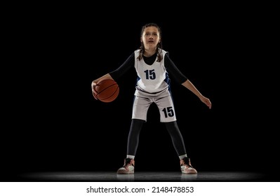 Portrait Of Teen Girl, Basketball Player In Motion, Dribbling Ball Isolated Over Black Studio Background. Beat The Defender. Concept Of Sport, Active Lifestyle, Health, Team Game And Ad