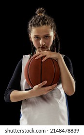 Portrait Of Teen Girl, Concentrated Basketball Player In Uniform Posing Isolated On Black Studio Background. Sportive And Active Lifestyle. Concept Of Professional Sport, Childhood, Motion, Team Game