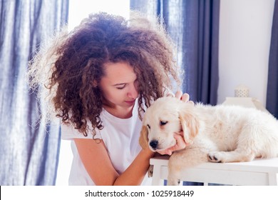 Portrait of teen girl with a small golden retriever in the room - Shutterstock ID 1025918449