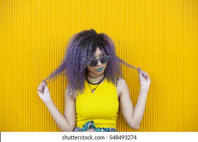 Portrait Of A Teen Woman With Purple Afro Hair And Colorful Glasses
