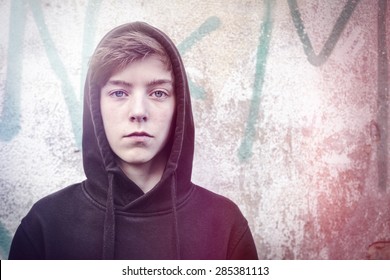 Portrait Of A Teenage Boy With Black Hoodie In Front Of A Graffiti