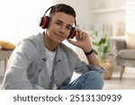 Portrait of teenage boy listening to music at home