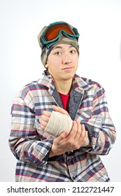 Portrait Of A Teenage Boy Showing His Broken Wrist All Bandaged Up After A Snowboarding Accident.