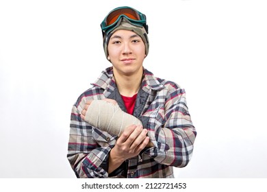 Portrait Of A Teenage Boy Showing His Broken Wrist All Bandaged Up After A Snowboarding Accident.