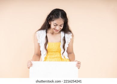 Portrait Of Teenage Girl Holding Sign Board And Looking Down