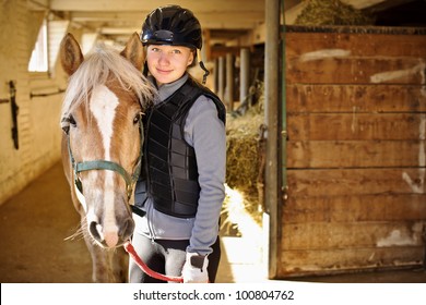 Portrait of teenage girl with horse in stable - Powered by Shutterstock