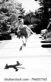 Portrait Of Teenage Girl In Leotard Jumping At The Street In Downtown Vancouver WA USA At Hot Summer Day, Black And White Picture, Shadow On The Ground 