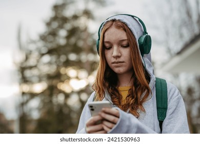 Portrait of teenage girl looking at her smartphone, sad, anxious, alone. Cyberbullying, girl is harassed, threated online. - Powered by Shutterstock