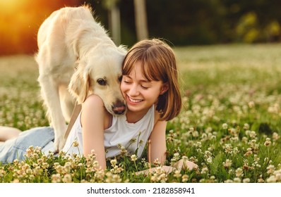 A Portrait of teenage girl petting golden retriever outside in sunset - Powered by Shutterstock