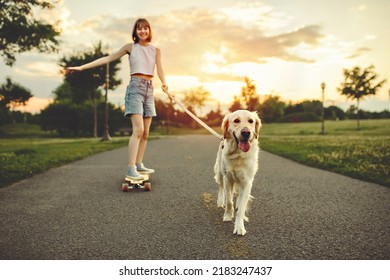 A Portrait of teenage girl petting golden retriever outside in sunset running on her longboard with dog