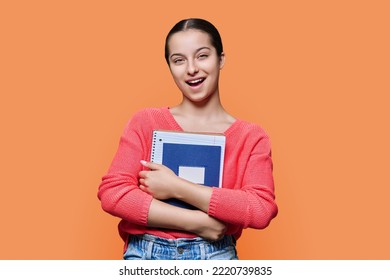 Portrait Of Teenage High School Student On On Orange Color Studio Background