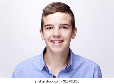 Portrait Of A Teenager Boy Smiling On Gray Background