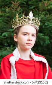 Portrait Of Teenager Boy Wearing Crown And Red Cape Pretending To Be A King