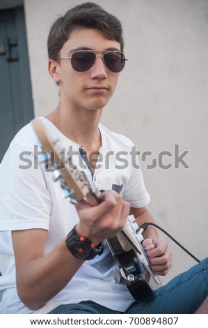 Similar – Young Boy Enjoying Music Playing Guitar Outdoors