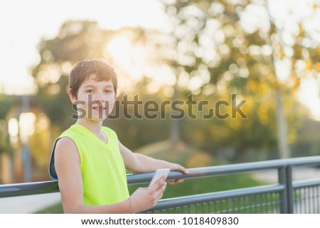 Similar – Teenager lächelnd, der sein Smartphone auf einem Basketballplatz aussieht.