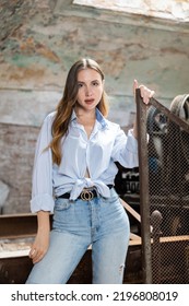 Portrait Of Tempting Woman Posing At Metal Grid Machine In Derelict Industrial Building.