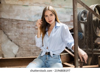 Portrait Of Tempting Woman Posing At Metal Grid Machine In Derelict Industrial Building.