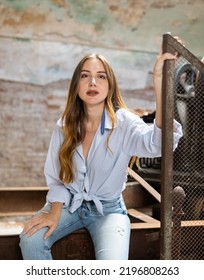 Portrait Of Tempting Woman Posing At Metal Grid Machine In Derelict Industrial Building.