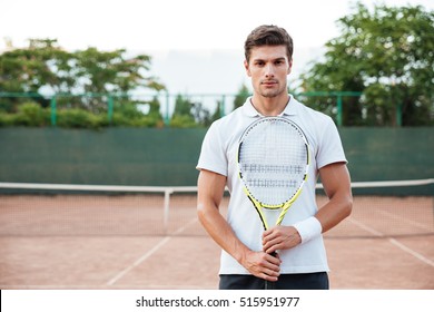 Portrait of tennis player man. front view. looking at camera. on the court