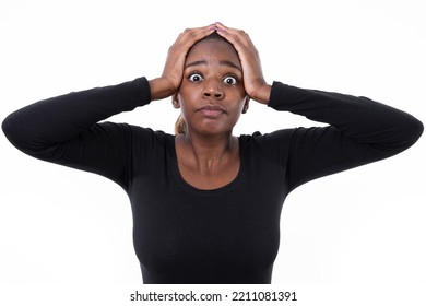 Portrait Of Terrified African American Woman. Scared Young Model In Black Shirt With Ponytail Looking At Camera With Hands On Head. Shock, Fear Concept.