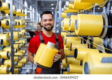 Portrait of textile industry worker holding thread spool by knitting machine. - Powered by Shutterstock