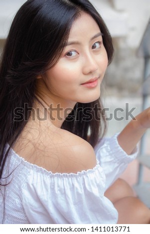 Portrait of thai adult beautiful girl White shirt blue jeans relax and smile