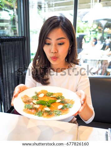 Portrait of Thai Asian Girl Presenting Spicy Salmon Salad Dish at Restaurant
