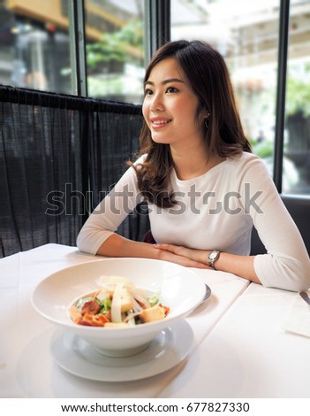 Portrait of Thai Asian Girl in a restaurant with Ceasar Salad on the table