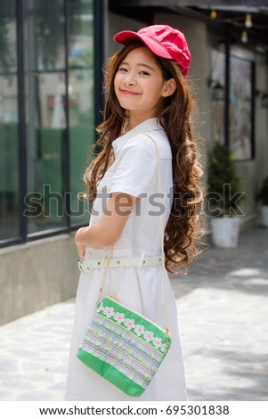 Portrait of thai teen beautiful girl white dress red hat happy and relax
