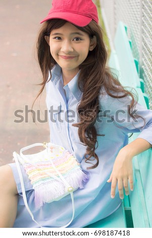 Portrait of thai teen beautiful girl blue dress red hat happy and relax