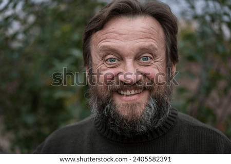 Portrait of a thinking or surprised senior man. Elderly bearded caucasian male in nature. Face bearded male dreams of solving issues, close up