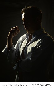 Portrait Of A Thoughtful 45-50-year-old Man In A Blue Unbuttoned Shirt Of Athletic Build, Contour Lighting, Dark Background.Maybe He's A Former Athlete, A Retired Military Man, A Truck Driver, 