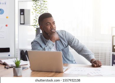 Portrait of thoughtful african american employee sitting at workplace in modern office, copy space