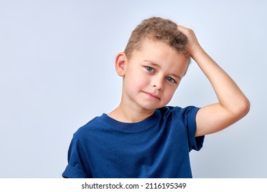portrait of thoughtful caucasian child boy in t-shirt looking at camera touching head, isolated on white studio background. handsome school boy is making a choice. human emotions concept