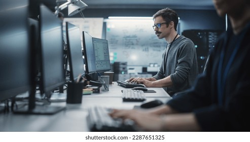 Portrait of a Thoughtful Engineer Working on Desktop Computer in a Technological Office Environment. Research and Development Department Writing Software Code for an Innovative Internet Project