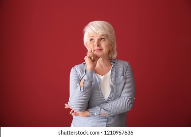 Portrait Of Thoughtful Mature Woman On Color Background